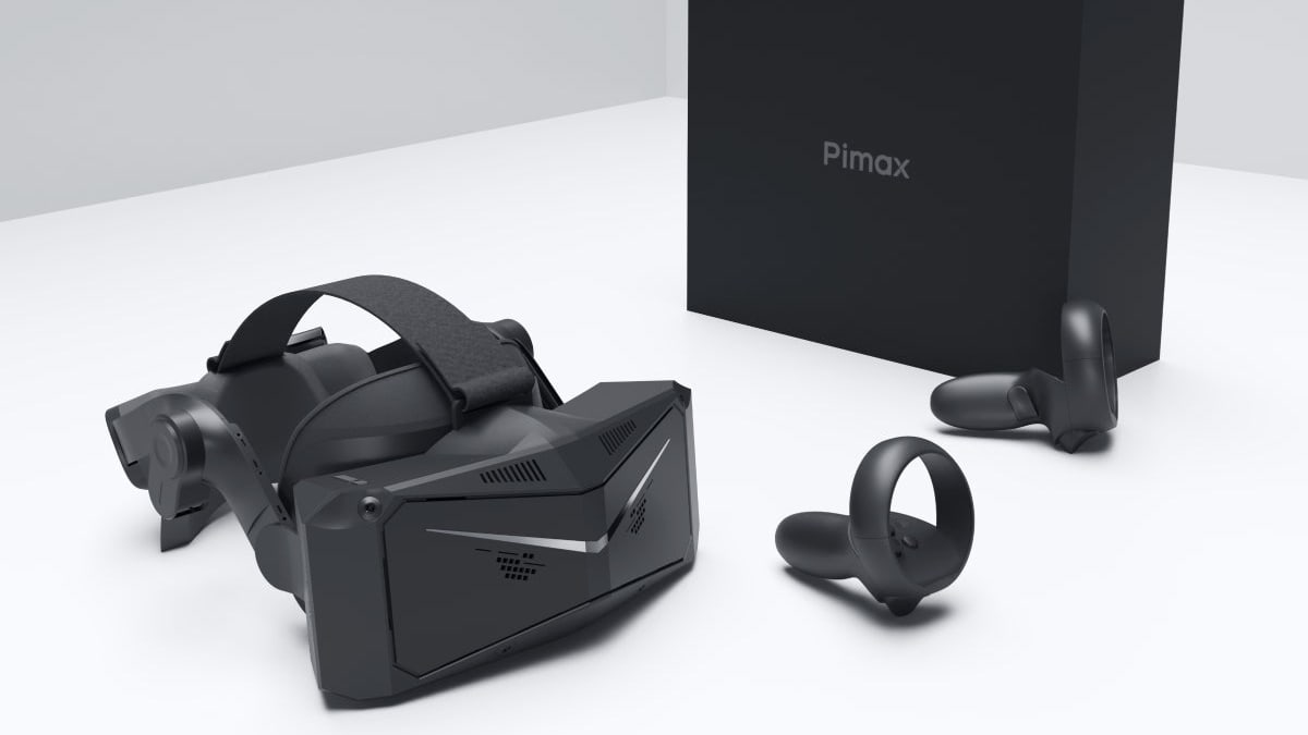 Pimax Crystal Light PC VR headset in black with its two ring controllers, in front of its black Pimax box