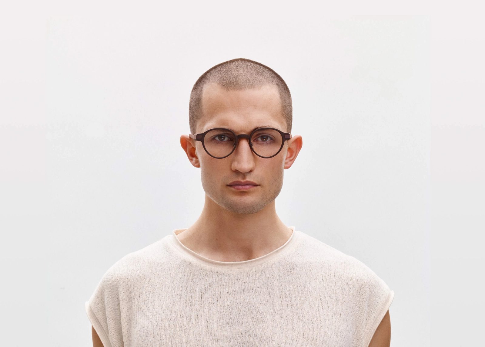 A person wearing the Even Realities G1 display smart glasses, round frames with no camera on them