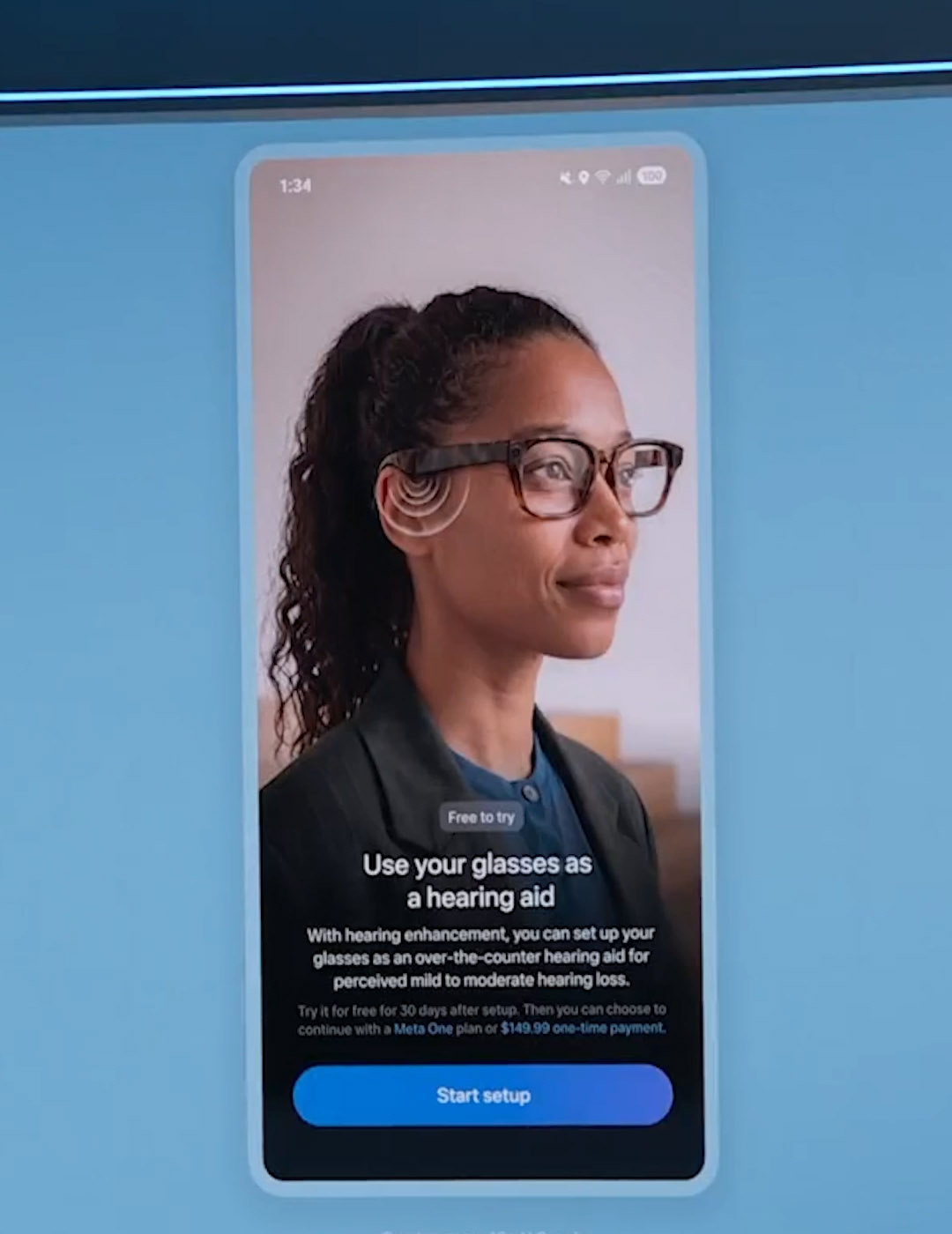 Meta keynote slide showing the phone setup screen for Hearing Enhancement, reading Use your glasses as a hearing aid, with a Start setup button and pricing of a Meta One plan or a $149.99 one-time payment