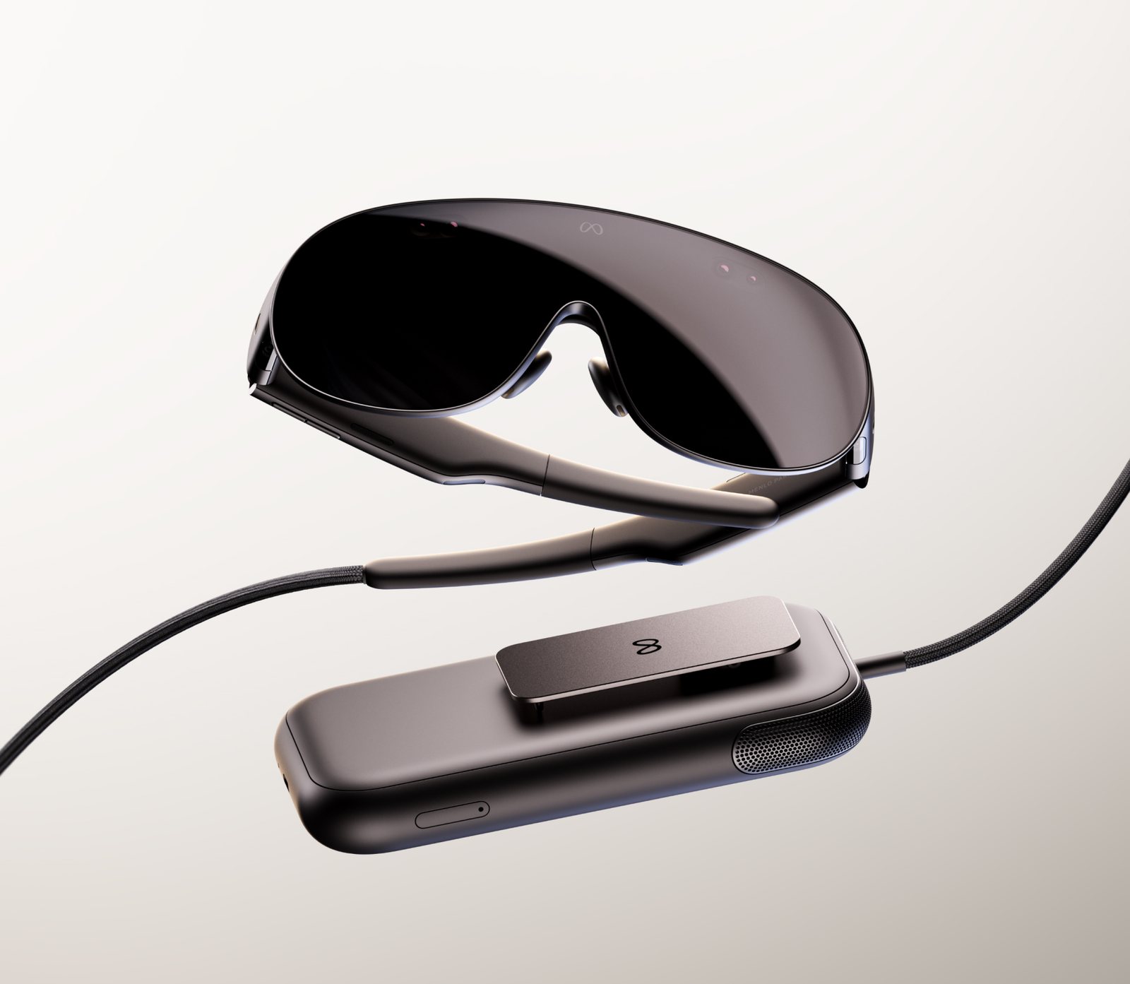 Meta VR Glasses in dark grey with a wraparound visor and temple arms, connected by a braided cable to a rectangular compute puck with a pocket clip