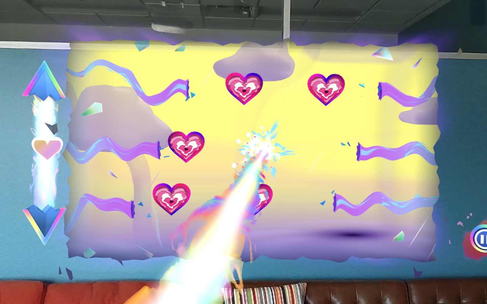 A Hyper Visor level pinned to a blue office wall above a leather couch: a torn-edged yellow rift holds pink heart targets while a rainbow energy beam fires from the player's hand